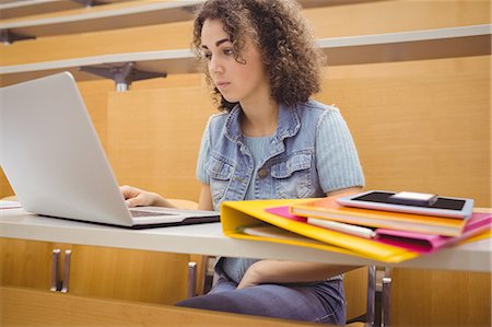 simsearch:6109-08396153,k - Pretty student in lecture hall using laptop Foto de stock - Sin royalties Premium, Código: 6109-08396425