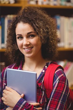 simsearch:6109-08396555,k - Pretty student in the library with tablet Photographie de stock - Premium Libres de Droits, Code: 6109-08396555