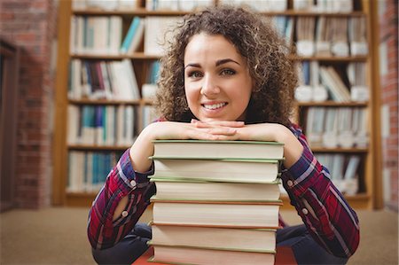 simsearch:6109-08396643,k - Pretty student in library with pile of books Foto de stock - Sin royalties Premium, Código: 6109-08396585