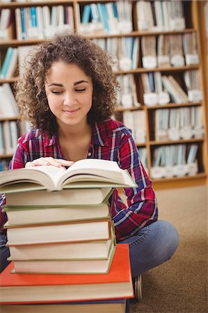 simsearch:400-08650429,k - Pretty student in library with pile of books Foto de stock - Royalty Free Premium, Número: 6109-08396589