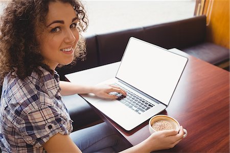 Pretty student having a coffee using laptop Stock Photo - Premium Royalty-Free, Code: 6109-08396504