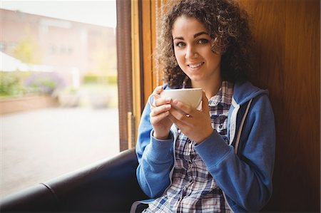 simsearch:6109-08396529,k - Pretty student sitting by the window Foto de stock - Royalty Free Premium, Número: 6109-08396520