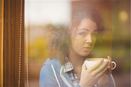 simsearch:6109-08395941,k - Pretty student sitting by the window having coffee Photographie de stock - Premium Libres de Droits, Code: 6109-08396527