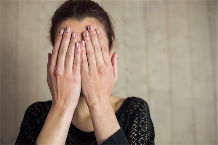 Woman covering face with hands Photographie de stock - Premium Libres de Droits, Code: 6109-08396648