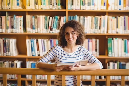 simsearch:400-08650429,k - Pretty student in library reading book Foto de stock - Royalty Free Premium, Número: 6109-08396606