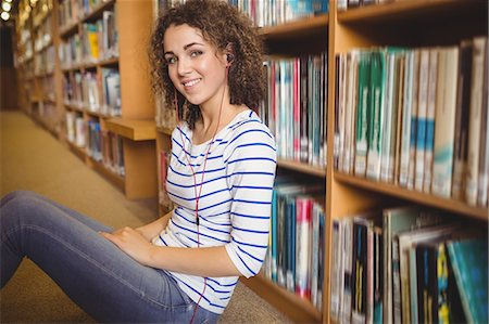 simsearch:6109-08396555,k - Pretty student in library reading on the floor Photographie de stock - Premium Libres de Droits, Code: 6109-08396618