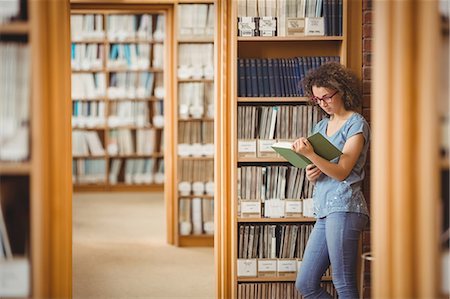 simsearch:400-08650429,k - Pretty student in library reading book Foto de stock - Royalty Free Premium, Número: 6109-08396627