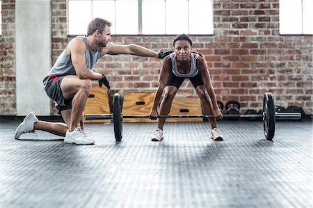 simsearch:6109-07498055,k - Woman lifting dumbbell with her trainer Stock Photo - Premium Royalty-Free, Code: 6109-08396784