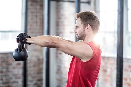 simsearch:6109-08396754,k - Muscular focused man lifting kettlebells Stock Photo - Premium Royalty-Free, Code: 6109-08396798