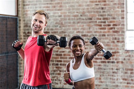 fitness trainer male - Smiling couple exercising with dumbbells Stock Photo - Premium Royalty-Free, Code: 6109-08396859