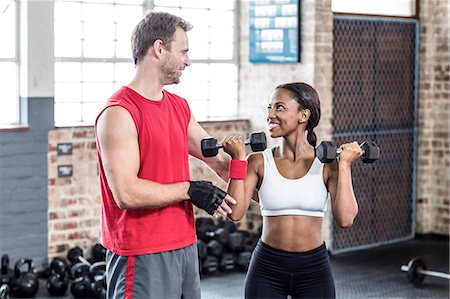 Smiling muscular couple lifting weight Stock Photo - Premium Royalty-Free, Code: 6109-08396861