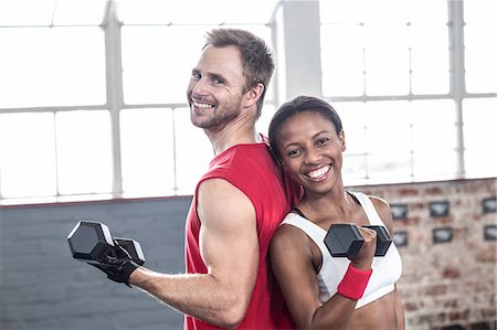 simsearch:6109-07498043,k - Smiling muscular couple lifting weight Foto de stock - Sin royalties Premium, Código: 6109-08396862