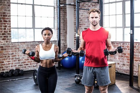 simsearch:6109-08396810,k - Focused muscular couple lifting dumbbells Foto de stock - Sin royalties Premium, Código: 6109-08396816