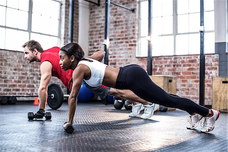 Fit couple doing dumbbell rows Stock Photo - Premium Royalty-Free, Code: 6109-08396819