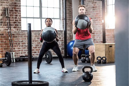 simsearch:6109-08397229,k - Muscular couple doing ball exercise Foto de stock - Sin royalties Premium, Código: 6109-08396827