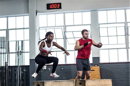 entrenador deportivo (hombre y mujer) - Muscular couple doing jumping squats Foto de stock - Sin royalties Premium, Código: 6109-08396829