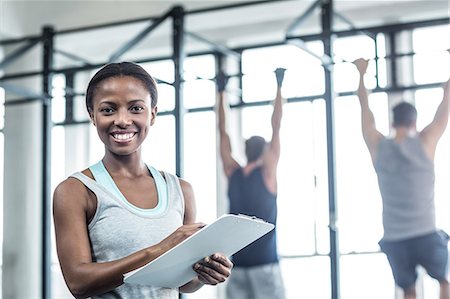 Smiling female trainer writing on clipboard Fotografie stock - Premium Royalty-Free, Codice: 6109-08396965