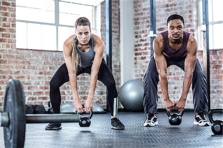 simsearch:6109-07498043,k - Fit couple lifting kettle bells Foto de stock - Sin royalties Premium, Código: 6109-08396996