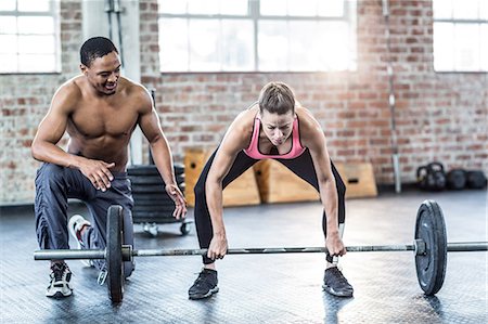 skinny man - Trainer helping woman with lifting barbell Stock Photo - Premium Royalty-Free, Code: 6109-08397021