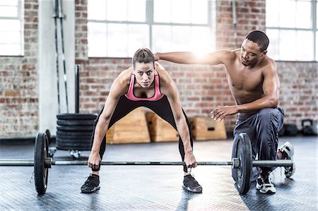 simsearch:6109-08397048,k - Trainer helping woman with lifting barbell Photographie de stock - Premium Libres de Droits, Code: 6109-08397022