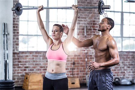 simsearch:6109-08397048,k - Trainer helping woman with lifting barbell Photographie de stock - Premium Libres de Droits, Code: 6109-08397033