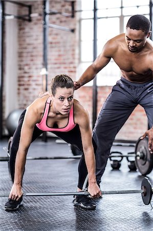 Trainer helping woman with lifting barbell Stock Photo - Premium Royalty-Free, Code: 6109-08397031