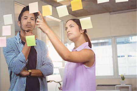 Businesswoman pointing at sticky notes Stock Photo - Premium Royalty-Free, Code: 6109-08397374