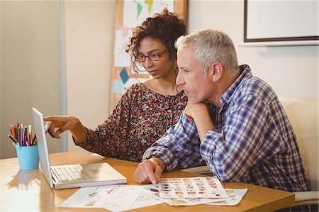 pointing finger - Creative businesswoman explaining colleague over laptop Stock Photo - Premium Royalty-Free, Code: 6109-08397491