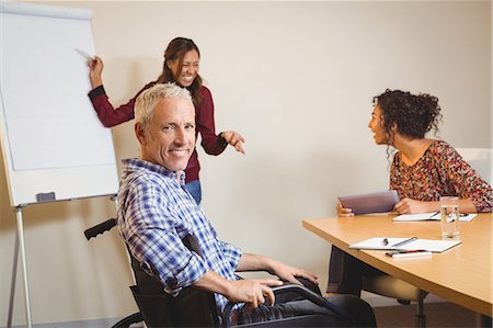 simsearch:6109-08397541,k - Businessman on wheelchair in creative office Stock Photo - Premium Royalty-Free, Code: 6109-08397552