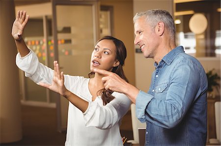 simsearch:6109-06007169,k - Businesswoman gesturing while explaining colleague Foto de stock - Sin royalties Premium, Código: 6109-08397627