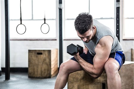 Fit man lifting heavy black dumbbell Stock Photo - Premium Royalty-Free, Code: 6109-08397753