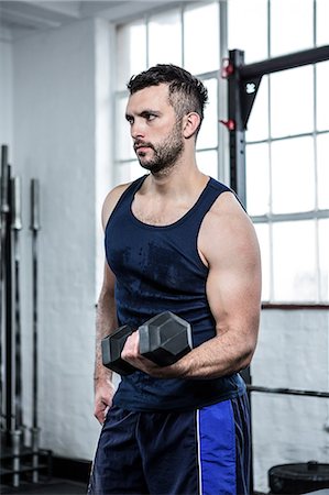 simsearch:6109-08397856,k - Fit man lifting heavy black dumbbells Stock Photo - Premium Royalty-Free, Code: 6109-08397793