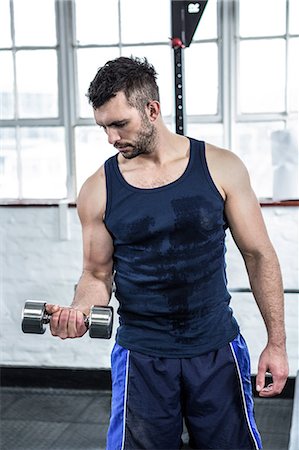 Fit man lifting heavy black dumbbells Stock Photo - Premium Royalty-Free, Code: 6109-08397794