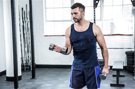 entraînement sportif - Fit man lifting heavy black dumbbells Photographie de stock - Premium Libres de Droits, Code: 6109-08397795