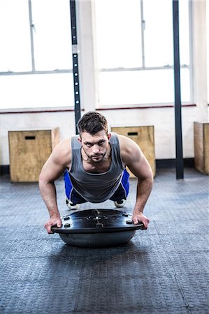 simsearch:6109-08397966,k - Fit man working out with bosu ball Photographie de stock - Premium Libres de Droits, Code: 6109-08397729