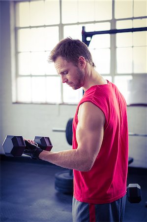 Fit man lifting heavy black dumbbells Stock Photo - Premium Royalty-Free, Code: 6109-08397846