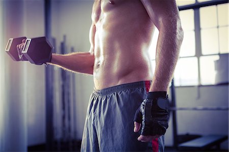 Fit man lifting heavy black dumbbell Stock Photo - Premium Royalty-Free, Code: 6109-08397853