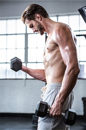 simsearch:6109-08397960,k - Fit shirtless man lifting dumbbells Stock Photo - Premium Royalty-Free, Code: 6109-08398058