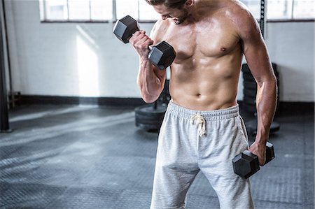 simsearch:6109-08397833,k - Fit shirtless man lifting dumbbells Foto de stock - Royalty Free Premium, Número: 6109-08398059