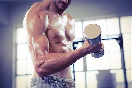 simsearch:6109-08396810,k - Fit shirtless man lifting dumbbell Foto de stock - Sin royalties Premium, Código: 6109-08398064