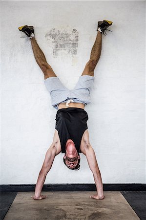 simsearch:6109-08398105,k - Fit man doing hand stand Stock Photo - Premium Royalty-Free, Code: 6109-08398017