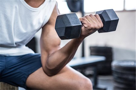 Fit man lifting heavy black dumbbells Stock Photo - Premium Royalty-Free, Code: 6109-08398113