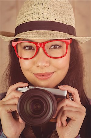 simsearch:6109-08690486,k - Attractive smiling hipster holding her camera Foto de stock - Sin royalties Premium, Código: 6109-08398278