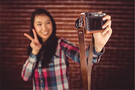 simsearch:6109-08398200,k - Attractive hipster gesturing peace sign Stock Photo - Premium Royalty-Free, Code: 6109-08398222