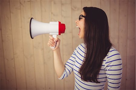 elegant background - Beautiful woman shouting with megaphone Stock Photo - Premium Royalty-Free, Code: 6109-08398345