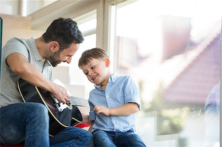 Father teaching son to play guitar Stock Photo - Premium Royalty-Free, Code: 6109-08398849