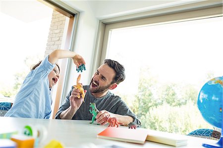 family playing in the kitchen - Father playing dinosaurs with son Stock Photo - Premium Royalty-Free, Code: 6109-08398858