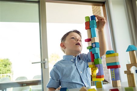 Cute boy playing with building blocks Stock Photo - Premium Royalty-Free, Code: 6109-08398863