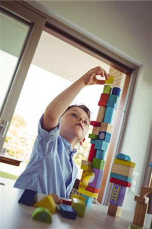 Cute boy playing with building blocks Stock Photo - Premium Royalty-Free, Code: 6109-08398864