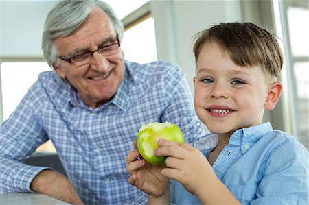 Grandfather and grandson eating an apple Stock Photo - Premium Royalty-Free, Code: 6109-08398894